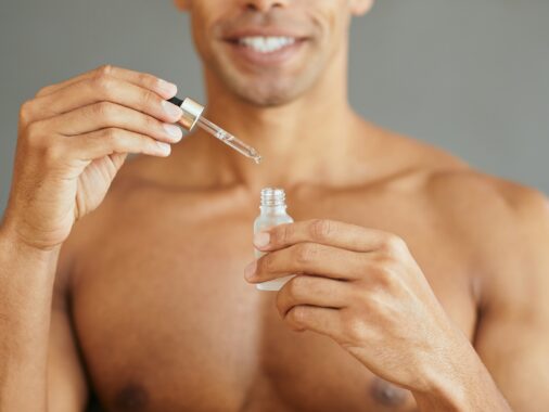 Close up of man using face serum.